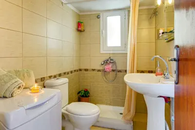 a bathroom with a toilet and a sink and a tub at Agapi Studios in Kato Daratso
