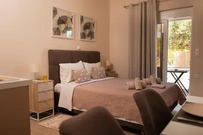 a bedroom with a large bed and a balcony at Plakoures Home in Kounoupidhianá