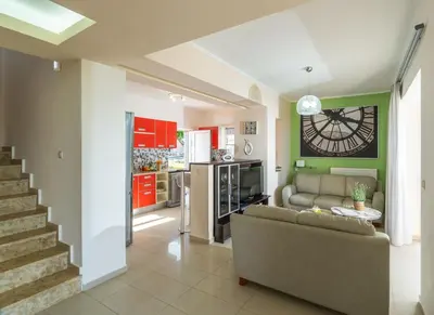 a living room with a couch and a kitchen at Villa Aretousa 1 in Agia Marina Nea Kydonias