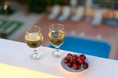 two glasses of wine and a plate of fruit on a table at Villa Aretousa 2 in Agia Marina Nea Kydonias