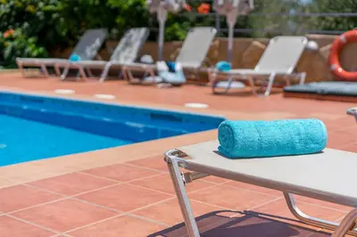a blue towel sitting on a table near a swimming pool at Villa Aretousa 2 in Agia Marina Nea Kydonias