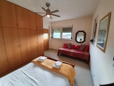 a bedroom with a bed and a red couch at Argo Villa Kalives in Kalyves