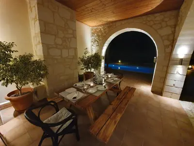 a dining room with a table and an archway at Argo Villa Kalives in Kalyves