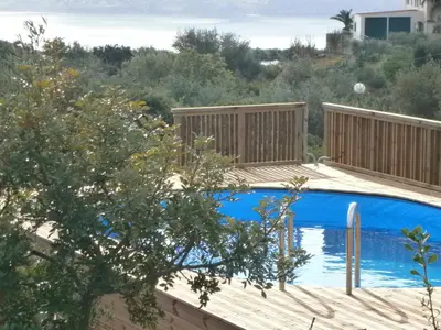a pool with a wooden deck and a blue swimming pool at Ktima Nikolaos in Arónion