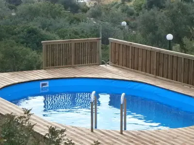a pool on a wooden deck with a blue swimming pool at Ktima Nikolaos in Arónion