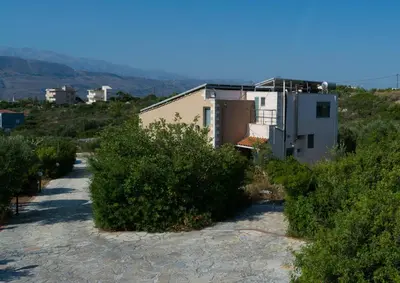 a house on the side of a hill with bushes at Ktima Nikolaos in Arónion