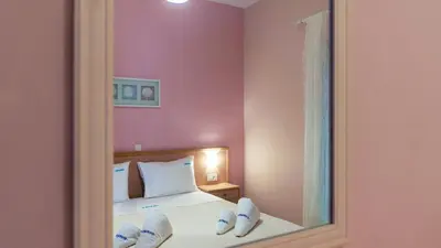 a reflection of a bedroom with a bed with a mirror at Vakakis-ME Apartments in Palaiochóra