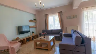 a living room with a couch and a tv at Vakakis-ME Apartments in Palaiochóra