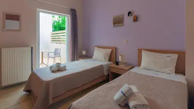 two beds in a room with a window at Vakakis-ME Apartments in Palaiochóra