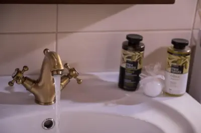 a sink with a faucet and two bottles of soap at Villa Fabrica in Thimiá