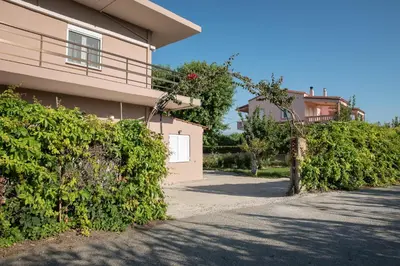 a building with a gate and bushes in front of it at Sirens House in Tavronitis