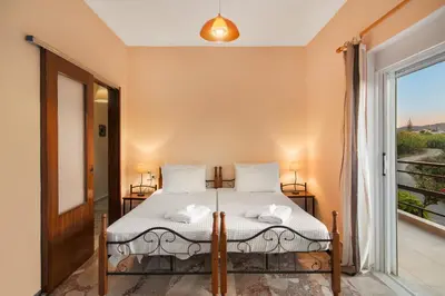 a bedroom with a bed and a large window at Sirens House in Tavronitis