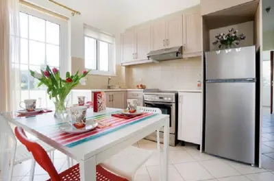 a kitchen with a white table and a refrigerator at Domus Creta in Kato Daratso