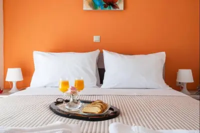a tray with bread and two glasses of orange juice on a bed at Domus Creta in Kato Daratso