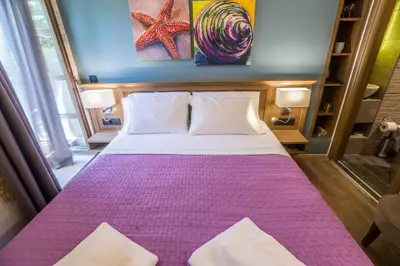 a bedroom with a large bed with a purple blanket at 11City Rooms in Chania Town