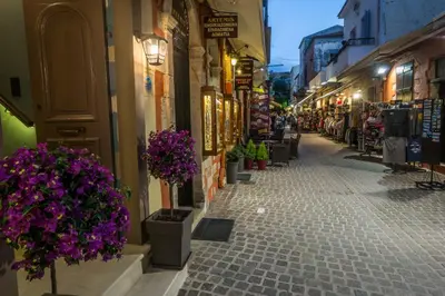 a street in a town with purple flowers inpots at 11City Rooms in Chania Town