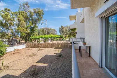 a balcony with a table and a view of a yard at Grameno Apartments in Kountoura Selino