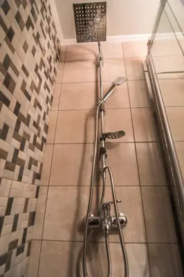 a shower in a bathroom with a tiled floor at Grameno Apartments in Kountoura Selino