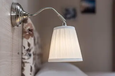 a lamp with a white shade attached to a couch at Grameno Apartments in Kountoura Selino