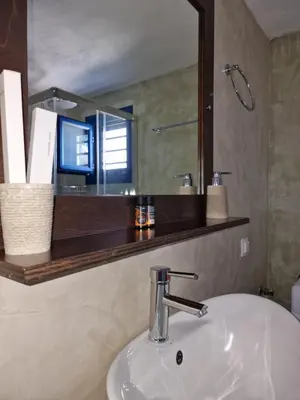 a bathroom with a sink and a mirror at John Akroyiali in Loutro