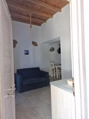 a living room with a blue couch and a table at John Akroyiali in Loutro