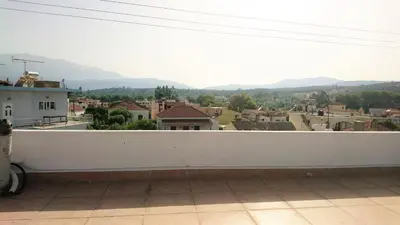 a white balcony with a view of a city at Crown Apartments in Kalyves