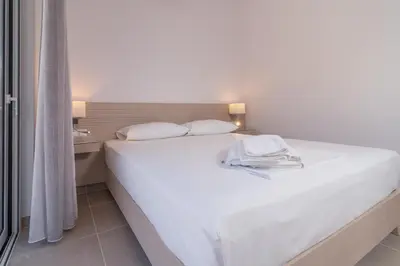 a large white bed in a room with a window at Villa-Palaiochora in Palaiochóra