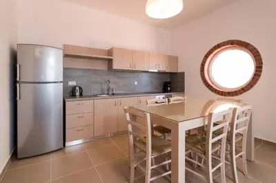 a kitchen with a table and a stainless steel refrigerator at Villa-Palaiochora in Palaiochóra