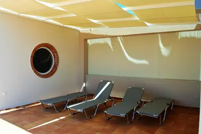 a waiting room with three chairs and a mirror at Villa-Palaiochora in Palaiochóra