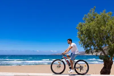 a man riding a bike on the beach at Blue Horizon in Palaiochóra