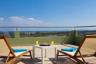a patio with two chairs and a table on a balcony at Villa Dimokratia in Kolymvari
