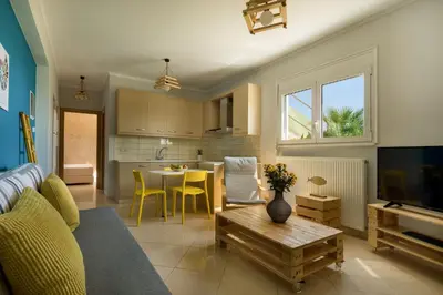 a living room with a couch and a table and a kitchen at Villa Dimokratia in Kolymvari