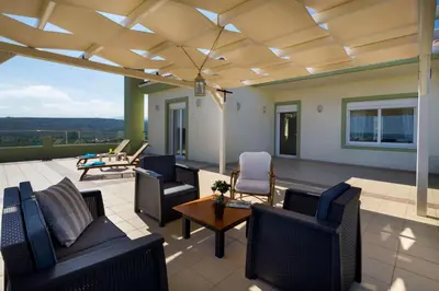 a patio with couches and chairs and a table at Villa Dimokratia in Kolymvari