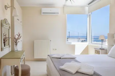 a bedroom with a bed and a desk and a window at Villa Anatoli in Stalos
