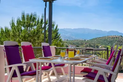 a table and chairs on a balcony with a view at Villa Anatoli in Stalos