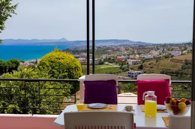 a table and chairs with a view of the ocean at Villa Anatoli in Stalos