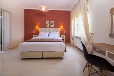 a bedroom with a large bed and a desk at Villa Anatoli in Stalos