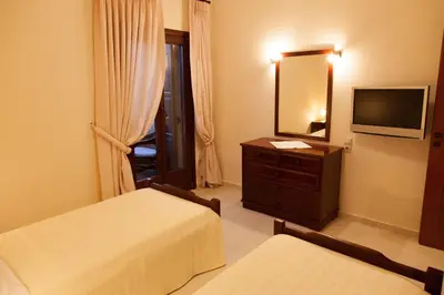 a hotel room with two beds and a television at Villa Allegra in Korfalónas