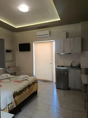 a room with a bed and a kitchen with a door at Kleri Beloni Rooms in Chania Town