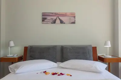 a bed with two pillows and flowers on it at Stefan's City Loft in Chania Town