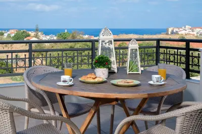 a wooden table with food on a balcony with chairs at Stefan's City Loft in Chania Town