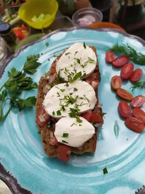 a blue plate with a piece of bread with sour cream at Poco Loco Bed & Breakfast in Chania Town