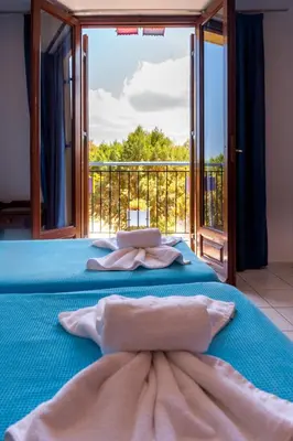 a bedroom with a blue bed with a large window at Poco Loco Bed & Breakfast in Chania Town