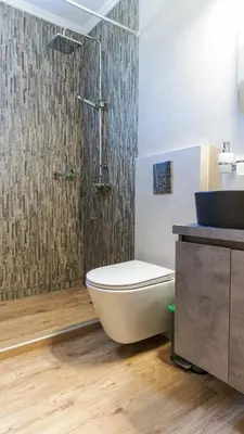 a bathroom with a sink and a toilet and a shower at Nicole Rooms in Palaiochóra