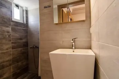a bathroom with a white sink and a shower at Nicole Rooms in Palaiochóra
