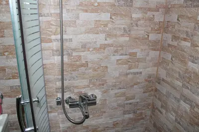 a shower in a bathroom with a glass door at My Rooms in Chania Town