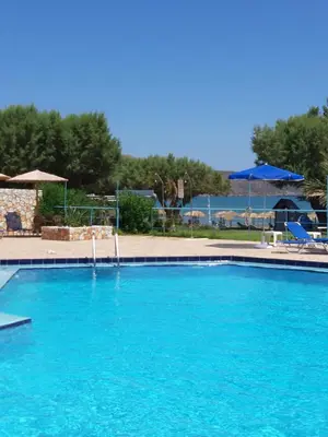 a large swimming pool with blue water at Eden Beach Hotel in Agia Marina Nea Kydonias