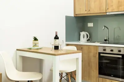 a kitchen with a table with a bottle of wine on it at Castell Hotel in Kissamos