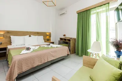 a bedroom with a bed and a green curtain at Castell Hotel in Kissamos