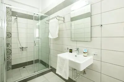 a white bathroom with a sink and a shower at Castell Hotel in Kissamos